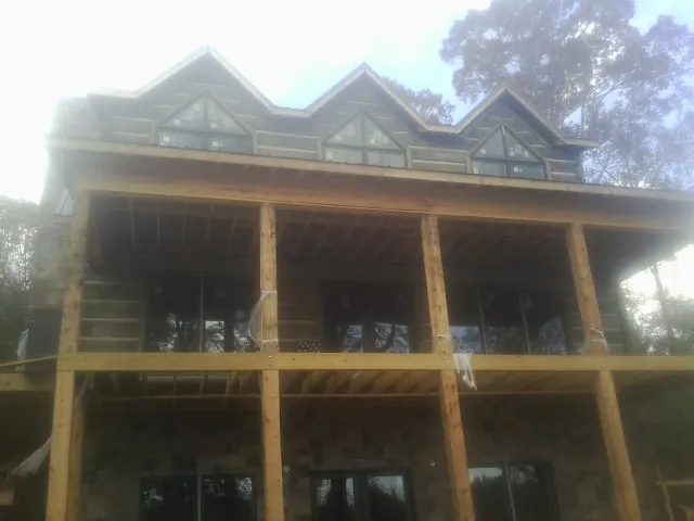 Dormers and porch framing on a large log home under construction — Roof Coating work by our crew in Tipp City